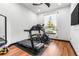 This exercise room includes wood flooring, a treadmill, stationary bike, natural light and a ceiling fan at 1570 Preserve Way, Clearwater, FL 33764