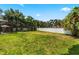Large grassy backyard with a white fence and tropical landscaping at 1570 Preserve Way, Clearwater, FL 33764