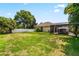Spacious backyard featuring a large grassy area and screened patio at 1570 Preserve Way, Clearwater, FL 33764