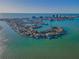 Expansive aerial perspective highlighting waterfront homes nestled on a peninsula, with picturesque landscapes, and serene waters at 526 Belle Isle Ave, Belleair Beach, FL 33786