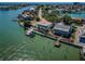 Breathtaking aerial view of a waterfront property featuring a private dock and lush green landscaping in a serene setting at 526 Belle Isle Ave, Belleair Beach, FL 33786