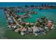 Panoramic aerial view of homes on a peninsula, bordered by sparkling waters and lush greenery, creating a picturesque coastal community at 526 Belle Isle Ave, Belleair Beach, FL 33786