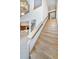Grand staircase with light wood and an overhead chandelier leads to upper levels with elegant design at 526 Belle Isle Ave, Belleair Beach, FL 33786