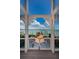 Beautiful water view of the dock, shrubbery and clear blue sky framed by a white wooden structure at 526 Belle Isle Ave, Belleair Beach, FL 33786