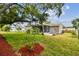 Landscaped backyard showcasing mature tree and young fruit trees at 3353 Columbus Dr, Holiday, FL 34691