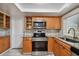 Kitchen with wood cabinets, granite counters, and window at 3353 Columbus Dr, Holiday, FL 34691