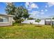Large backyard with a white privacy fence and young trees at 3353 Columbus Dr, Holiday, FL 34691