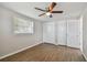 Bedroom with wood-look flooring, ceiling fan and double door closet at 3353 Columbus Dr, Holiday, FL 34691