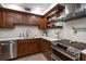 Modern kitchen with stainless steel appliances and dark wood cabinetry at 150 Belleview Blvd # 704, Belleair, FL 33756