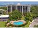 Aerial view of condo complex with pool and landscaping at 150 Belleview Blvd # 704, Belleair, FL 33756