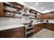 Updated kitchen with dark wood cabinets, quartz countertops and open shelving at 150 Belleview Blvd # 704, Belleair, FL 33756