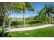 Peaceful waterfront path with lush landscaping and palm trees at 2746 Via Tivoli # 132B, Clearwater, FL 33764