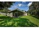 Home's exterior showcasing screened porch and grassy yard at 1377 N Mcmullen Booth Rd # 1377, Clearwater, FL 33759