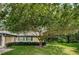Landscaped yard with a large tree and a charming house exterior at 1377 N Mcmullen Booth Rd # 1377, Clearwater, FL 33759