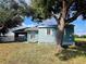 Quaint house with light blue siding and a large tree at 7267 Teaberry St, Englewood, FL 34224
