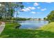 Scenic lake view showcasing lush green trees and blue skies in a serene community setting at 3051 Overlook Pl, Clearwater, FL 33760