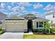 One-story house with stone accents, two-car garage, and lush landscaping at 30964 Penny Surf Loop, Wesley Chapel, FL 33545