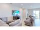 Living room with sectional sofa, large TV, and plenty of natural light at 30964 Penny Surf Loop, Wesley Chapel, FL 33545