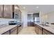 Modern kitchen with dark wood cabinets, granite countertops, and stainless steel appliances at 30964 Penny Surf Loop, Wesley Chapel, FL 33545
