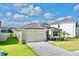 One-story house with stone accents, two-car garage, and lush landscaping at 30964 Penny Surf Loop, Wesley Chapel, FL 33545