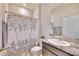 Clean bathroom with granite countertop, shower, and floral shower curtain at 30964 Penny Surf Loop, Wesley Chapel, FL 33545