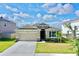 One-story house with stone accents, two-car garage, and lush landscaping at 30964 Penny Surf Loop, Wesley Chapel, FL 33545