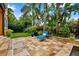 Secluded backyard oasis with lush tropical landscaping, a comfortable lounge chair, and a relaxing ambiance at 620 Ponce De Leon Dr, Tierra Verde, FL 33715