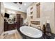 Elegant bathroom showcasing an oval soaking tub, dark wood cabinets, and decorative wall features at 620 Ponce De Leon Dr, Tierra Verde, FL 33715