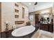 A luxurious bathroom features a soaking tub, dark granite counters, and decorative tiled wall niches at 620 Ponce De Leon Dr, Tierra Verde, FL 33715