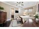 Comfortable bedroom features dark hardwood floors, a ceiling fan, a TV and a connected en suite bathroom at 620 Ponce De Leon Dr, Tierra Verde, FL 33715