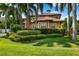 Beautiful home with a tile roof, an orange exterior, a manicured lawn and lush landscaping at 620 Ponce De Leon Dr, Tierra Verde, FL 33715