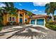 Charming Mediterranean-style home with a paver driveway, mature landscaping, and a three-car garage at 620 Ponce De Leon Dr, Tierra Verde, FL 33715