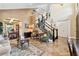 Open-concept living room with marble floors, a staircase with dark wood and white banisters, and dining room in the background at 620 Ponce De Leon Dr, Tierra Verde, FL 33715