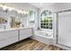 Modern bathroom featuring white double vanity, soaking tub, and window view at 3181 Sterling St, Tarpon Springs, FL 34688