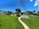 Expansive lawn of a well-maintained community with palm trees and shuffleboard courts at 6201 2Nd E St # 73, St Pete Beach, FL 33706