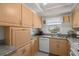 Bright kitchen featuring light wood cabinets, solid countertops, and white appliances at 6201 2Nd E St # 73, St Pete Beach, FL 33706
