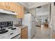 Bright kitchen featuring white appliances that opens into a living area at 6201 2Nd E St # 73, St Pete Beach, FL 33706