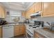 Bright kitchen featuring light wood cabinets, solid countertops, and white appliances at 6201 2Nd E St # 73, St Pete Beach, FL 33706