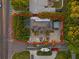 An aerial view of a single-story home surrounded by lush landscaping and a driveway with multiple cars at 6465 30Th S St, St Petersburg, FL 33712