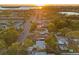 A sunny aerial view of a neighborhood with lush trees and a glimpse of the water at sunset at 6465 30Th S St, St Petersburg, FL 33712