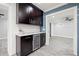 Wet bar area features a beverage fridge, marble countertops, and dark cabinets in an open concept living space at 6465 30Th S St, St Petersburg, FL 33712