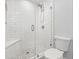 A bathroom featuring a glass shower, white tile walls, and pebble flooring at 6465 30Th S St, St Petersburg, FL 33712