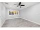 A bedroom featuring wood-look flooring, neutral walls, and a window with white shutters at 6465 30Th S St, St Petersburg, FL 33712