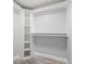 Walk-in closet with white shelving and hanging rods, and gray wood-look flooring at 6465 30Th S St, St Petersburg, FL 33712