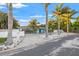 Charming single-story home with a circular driveway, palm trees, and a white picket fence at 6465 30Th S St, St Petersburg, FL 33712