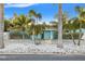 Beautiful blue single-story home featuring a lovely front yard with mature palm trees at 6465 30Th S St, St Petersburg, FL 33712