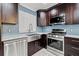 A modern kitchen featuring stainless steel appliances, light blue backsplash, and dark wood cabinets at 6465 30Th S St, St Petersburg, FL 33712