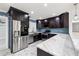 Modern kitchen features stainless steel appliances, dark wood cabinets, marble countertops, and blue tile backsplash at 6465 30Th S St, St Petersburg, FL 33712