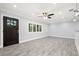 Bright living room featuring gray wood floors, a ceiling fan, and a window with plantation shutters at 6465 30Th S St, St Petersburg, FL 33712