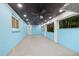A spacious covered patio with blue textured walls, a dark ceiling, and ceiling fans for comfort at 6465 30Th S St, St Petersburg, FL 33712
